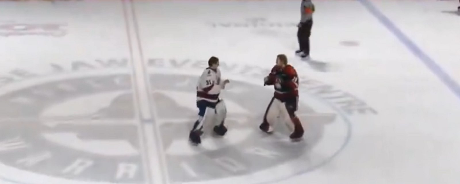 Goalie fight at center ice after all hell breaks loose.