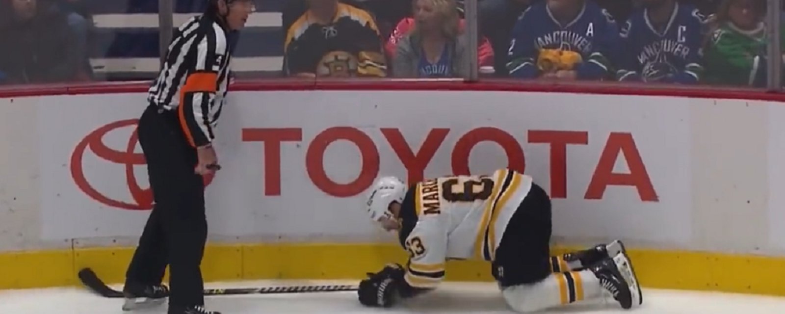 Referee Wes McCauley takes out Brad Marchand.