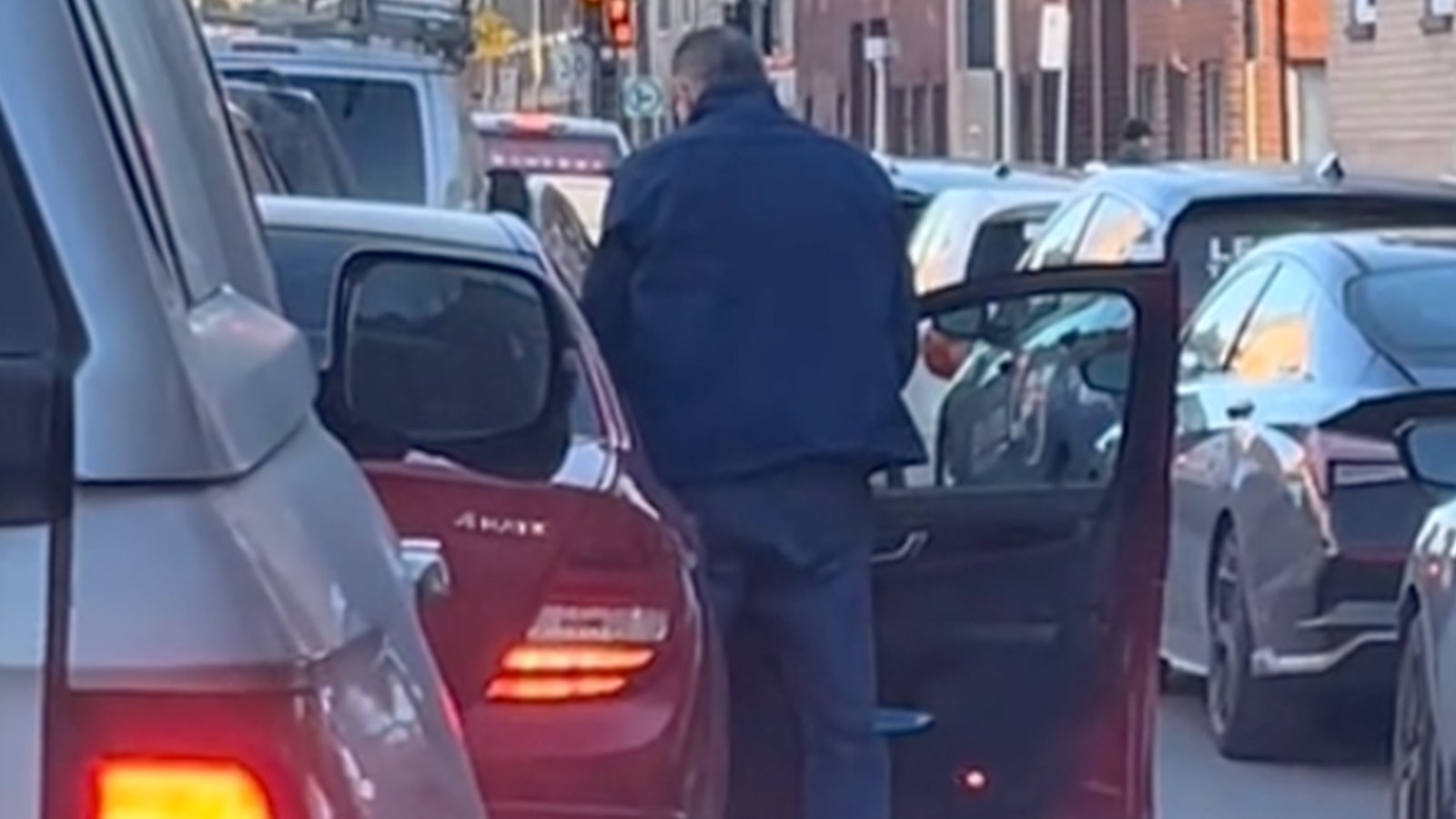 Un homme sort d'une voiture pour faire ses besoins en pleine rue à Montréal