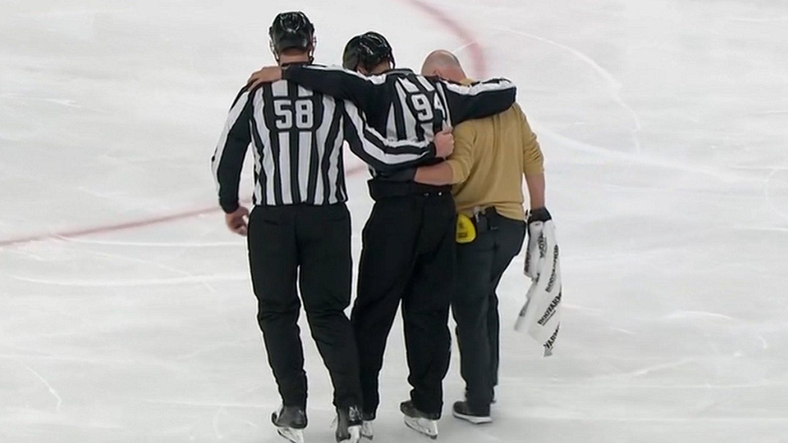 NHL official carried off the ice after getting clotheslined in the head.