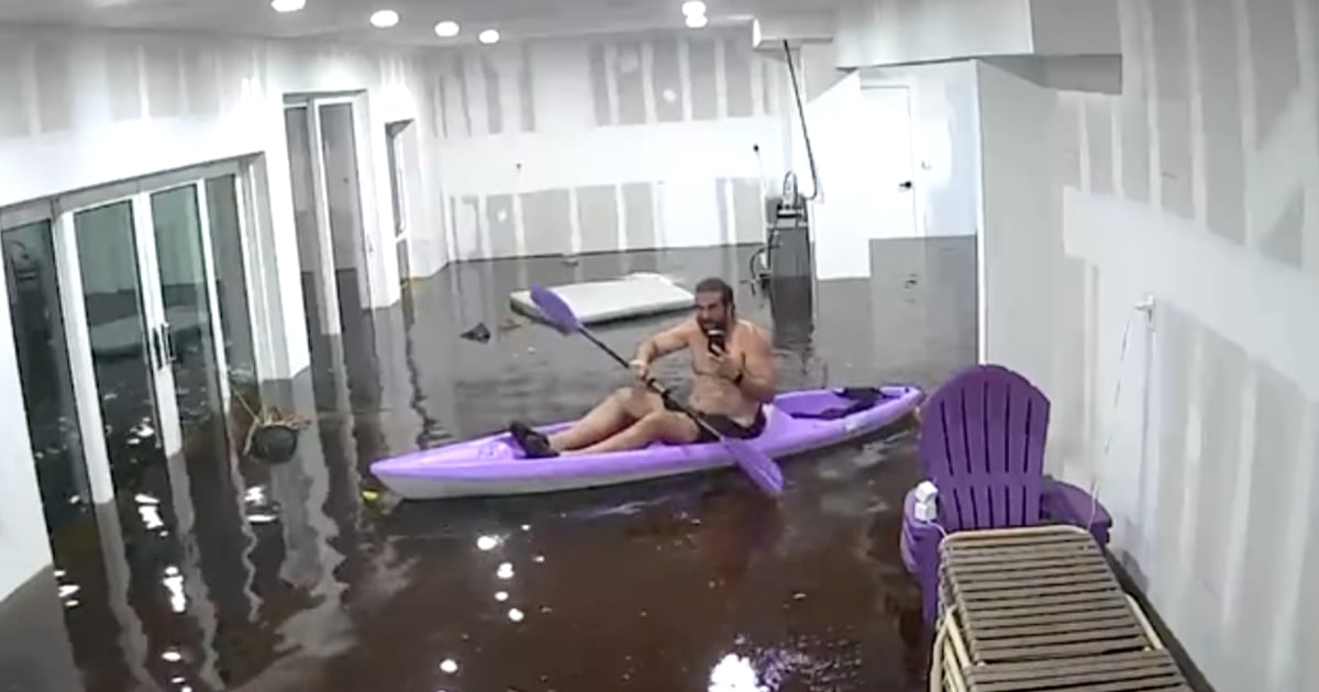 Un homme fait du kayak dans son salon après le passage de l'ouragan Hélène