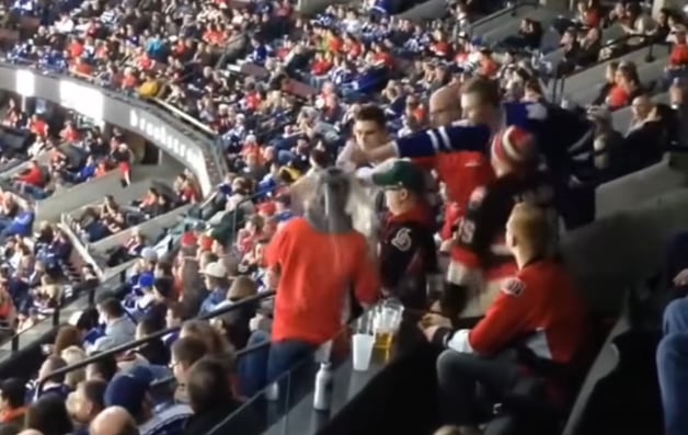 Un partisan des Leafs vide sa bière sur la tête d'un fan des Sens
