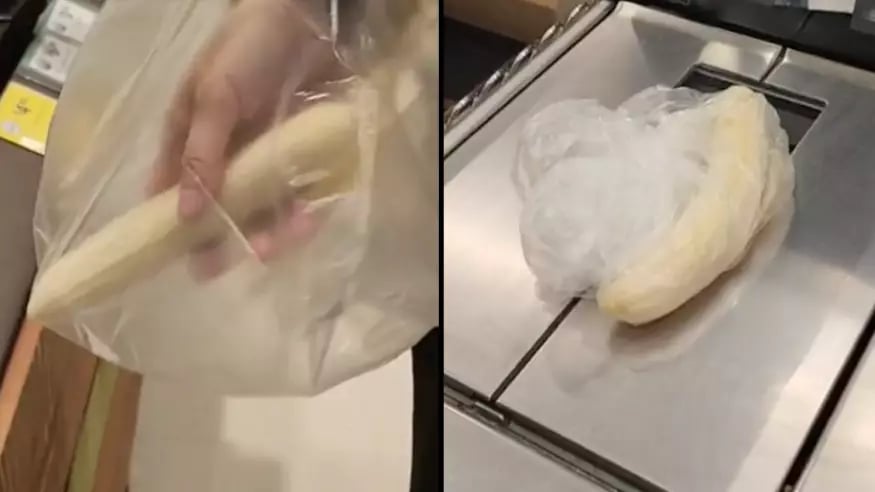 Un homme épluche ses bananes à l'épicerie pour les payer moins cher. 