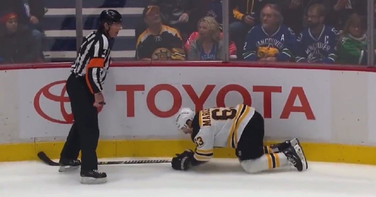 Referee Wes McCauley takes out Brad Marchand.