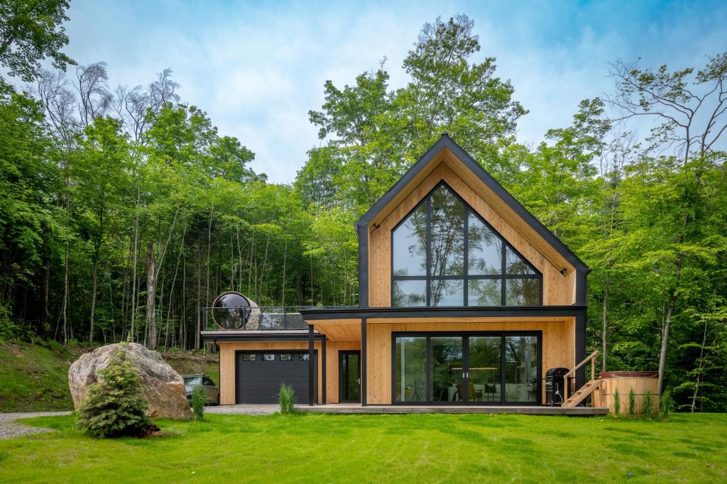 Construction contemporaine d'inspiration scandinave baignée de lumière et sise à flanc de montagne