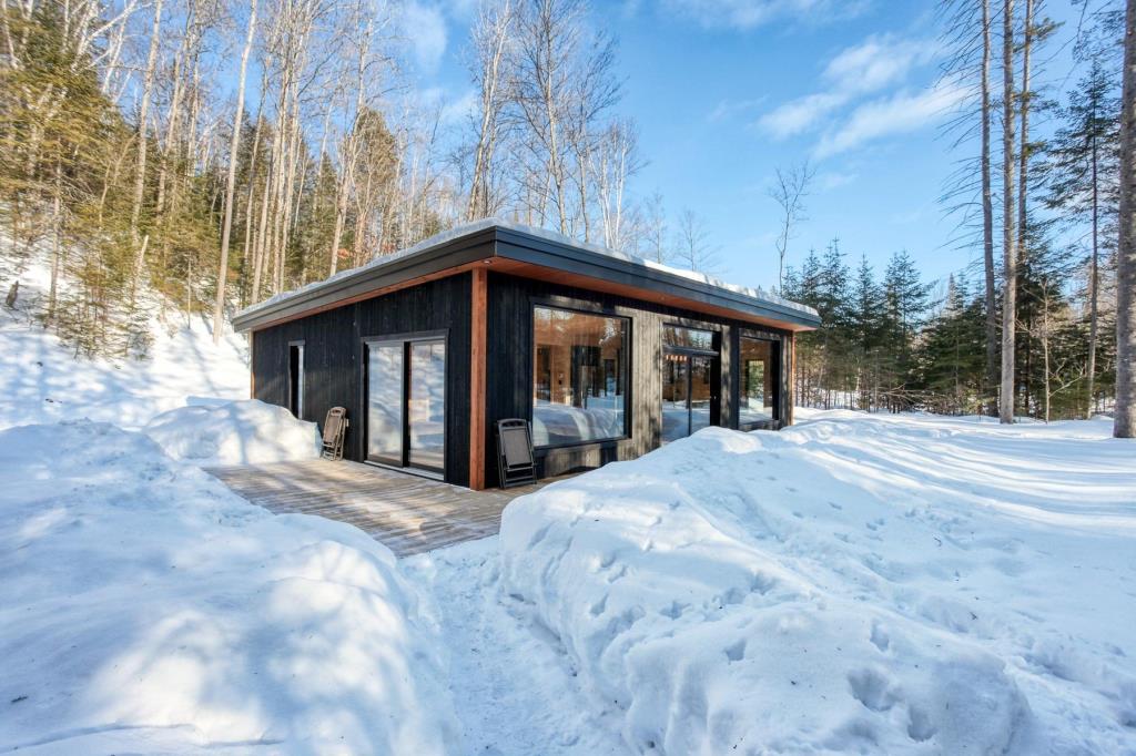 Confort, sérénité et nature vous attendent dans cette construction rustique-chic longeant une rivière 