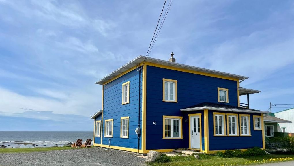 Des vues spectaculaires vous attendent dans cette chaleureuse demeure avec superbe plage privée en bordure du fleuve