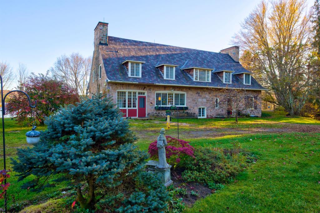Cottage en pierre au charme intemporel bordant un lac dans les Laurentides