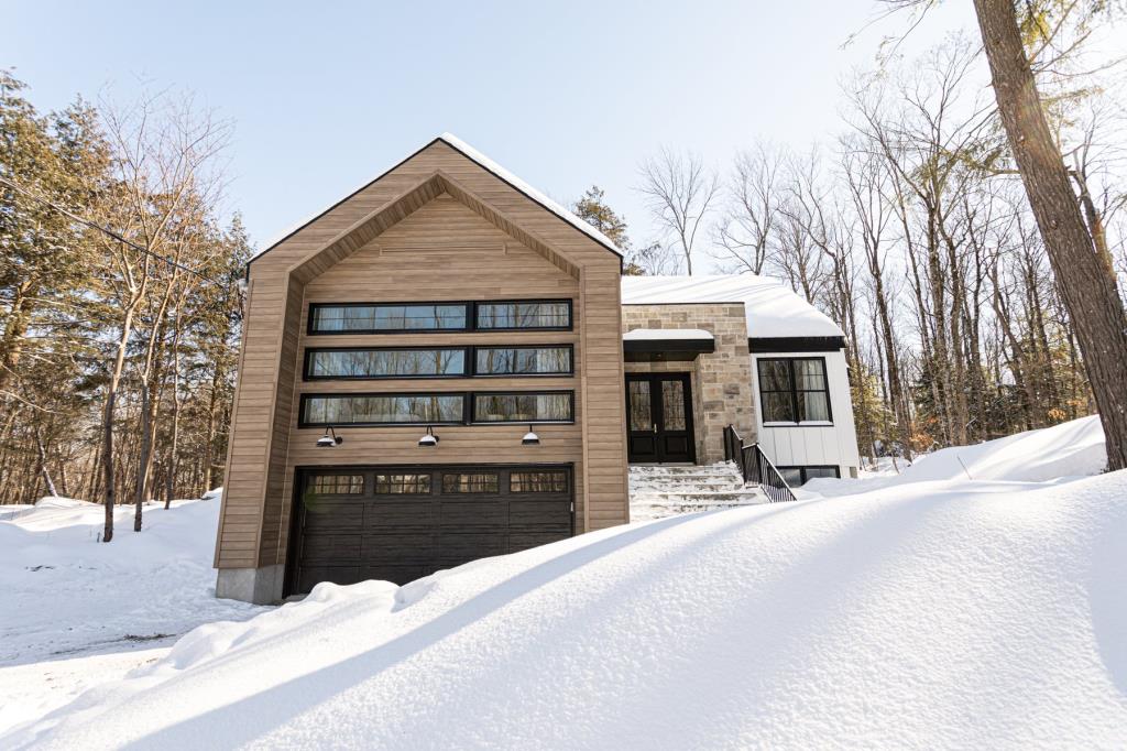 Splendide cottage contemporain de 5 chambres et 3 salles de bain logé sur un terrain boisé de 73 958 pi²