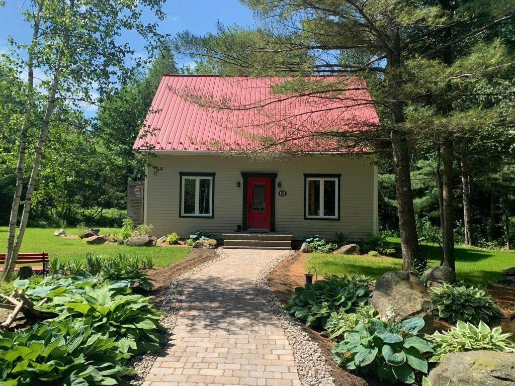 Chaleureuse chaumière remise au goût du jour blottie dans un écrin de verdure avec vue sur la montagne de Bromont