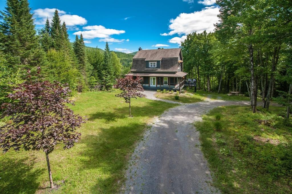 Sublime maison champêtre sise sur un terrain boisé de 173 476 pi² longeant une rivière avec plage privée