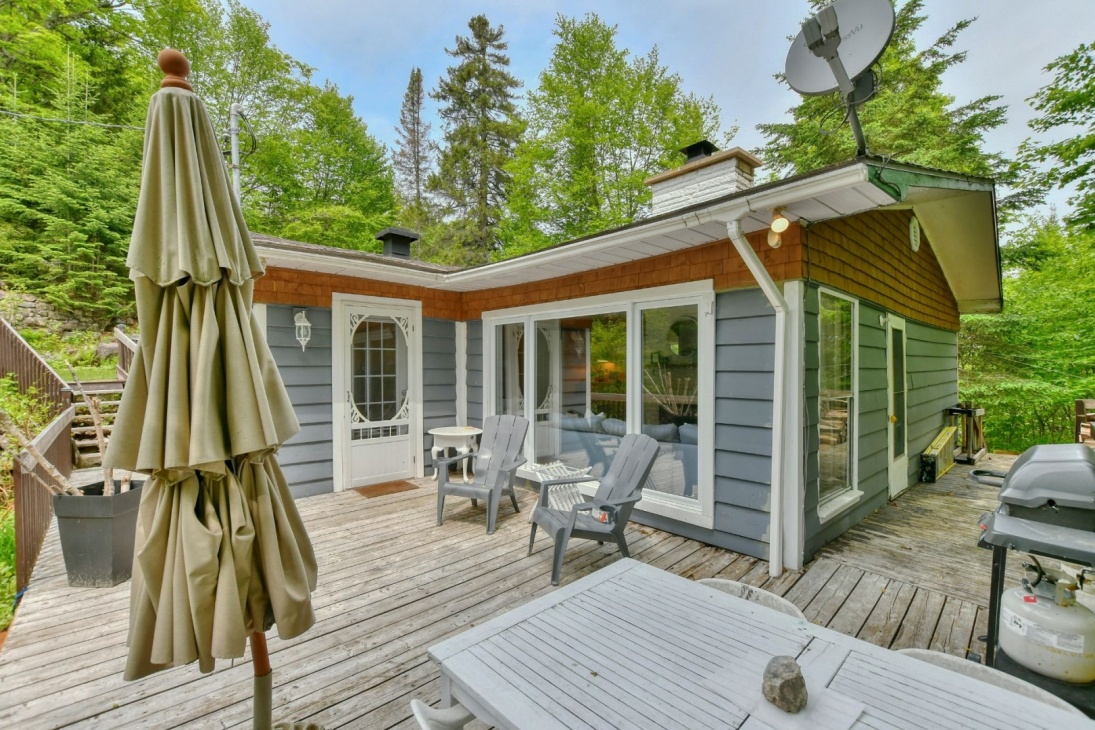 Cette maison à 274 500$ vous offre un intérieur chaleureux, un terrain boisé intime et l'accès à un lac