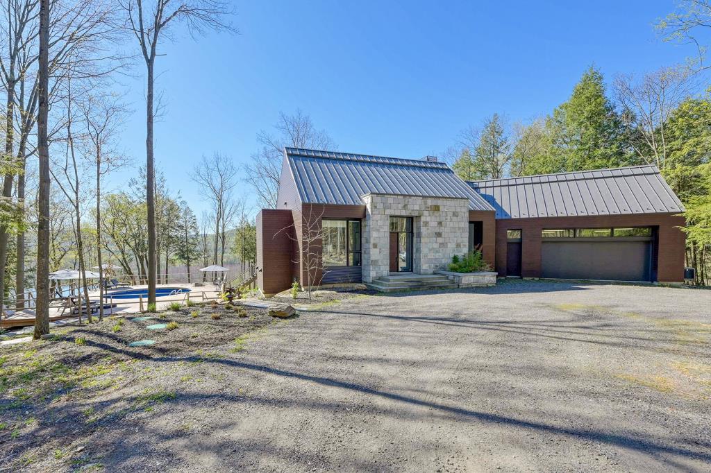 Vue saisissante et somptueux intérieur vous attendent dans cette demeure nichée sur 6,2 acres de boisé à flanc de montagne 