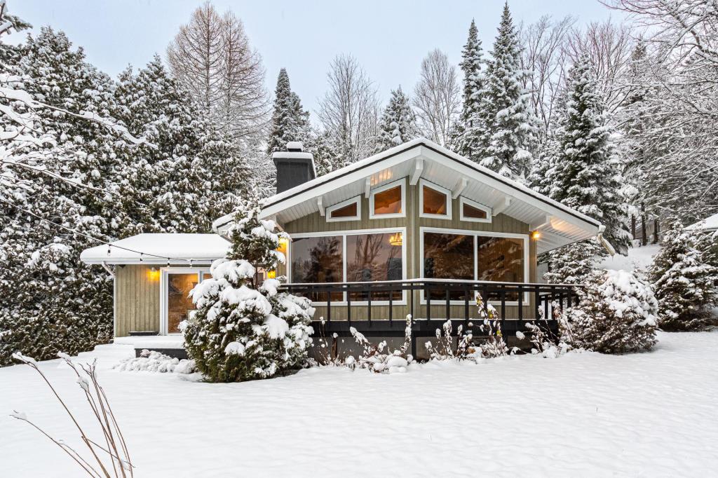 Chaleureusement accueillante, cette propriété surplombant un lac vous charmera été comme hiver