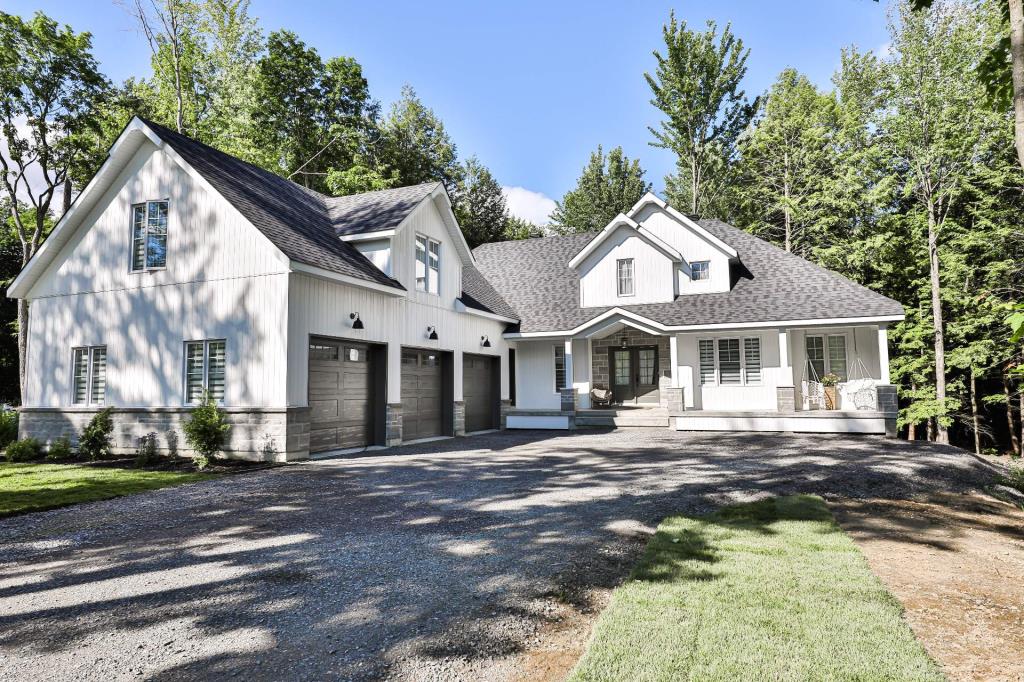 Majestueuse demeure d'inspiration farmhouse contemporaine avec une cuisine de rêve et un boisé en guise de cour
