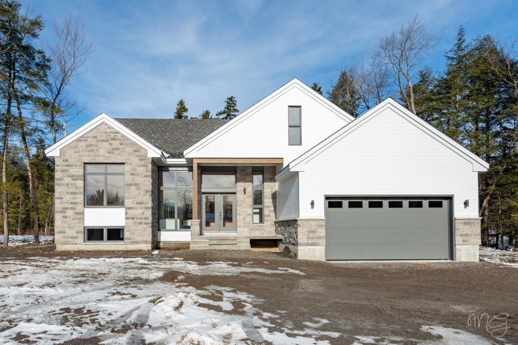 Plain-pied contemporain conçu avec le souci du détail, offrant la tranquillité d'un boisé à 2 mins de la ville