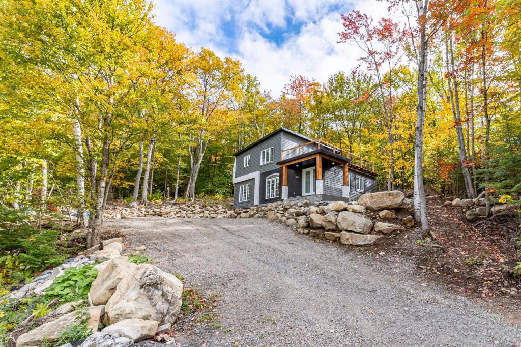 Élégante maison à 379 000$ camouflée dans une forêt de 120 283 pi² au cœur d'un secteur enchanteur des Laurentides 